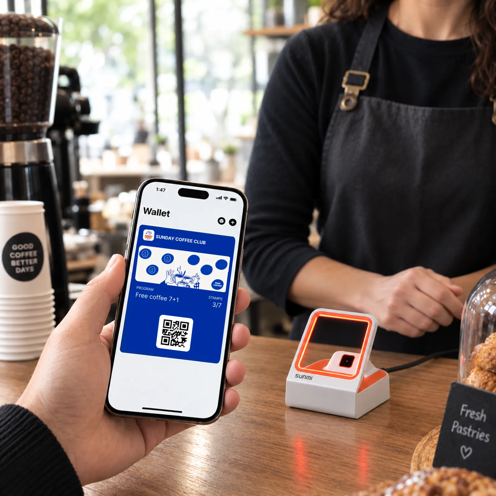 Πελάτης δείχνει την κάρτα του από το wallet ενώ ο υπάλληλος τη σαρώνει με scanner ταμείου